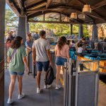 three people lining up to get on a theme park ride